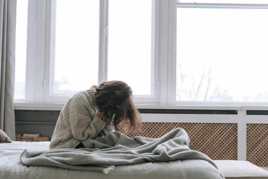Woman sitting in quiet morning meditation by a window, practicing nervous system regulation for spiritual awakening